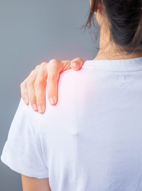 woman with her shoulder sprain, muscle painful during overwork. Girl having body problem after wake up. Shoulder ache, Scapular pain, office syndrome and ergonomic concept